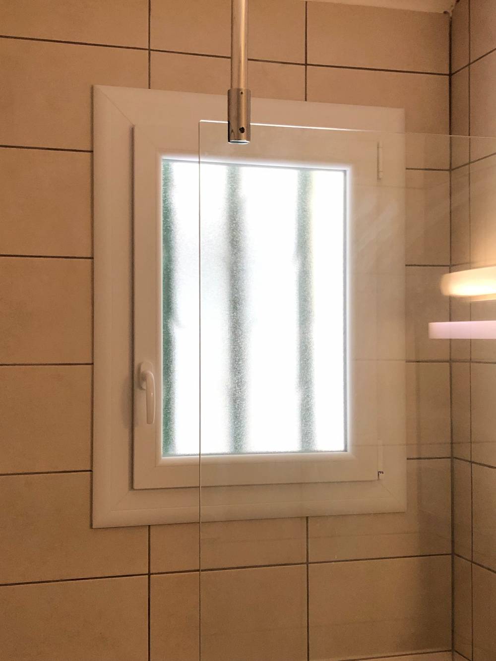 Pose d'une fenêtre de salle de bain opaque en PVC avec double vitrage